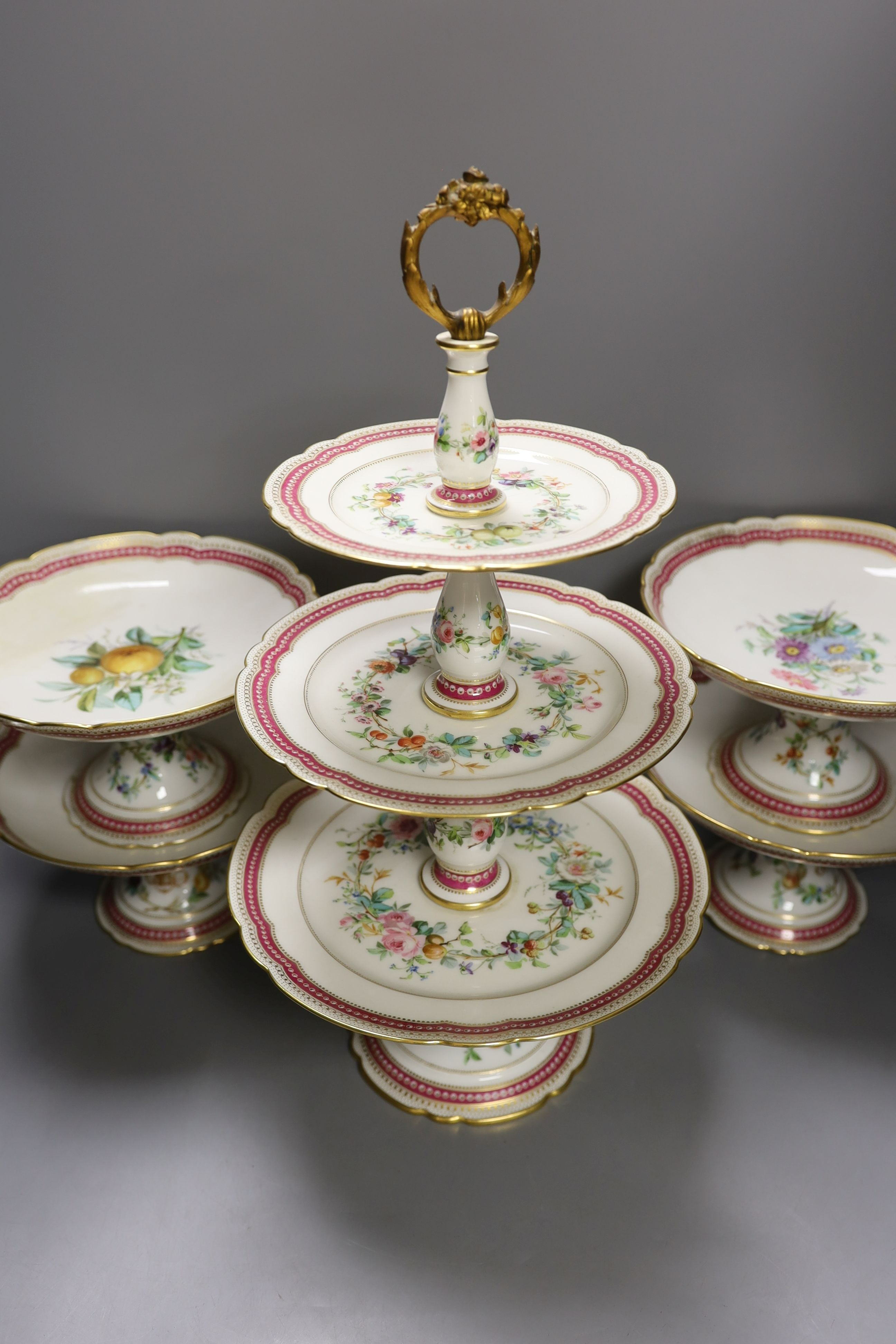 A late 19th century Paris porcelain floral part dessert service, with 2 pairs of comports, a three tier cake stand and eleven dishes.